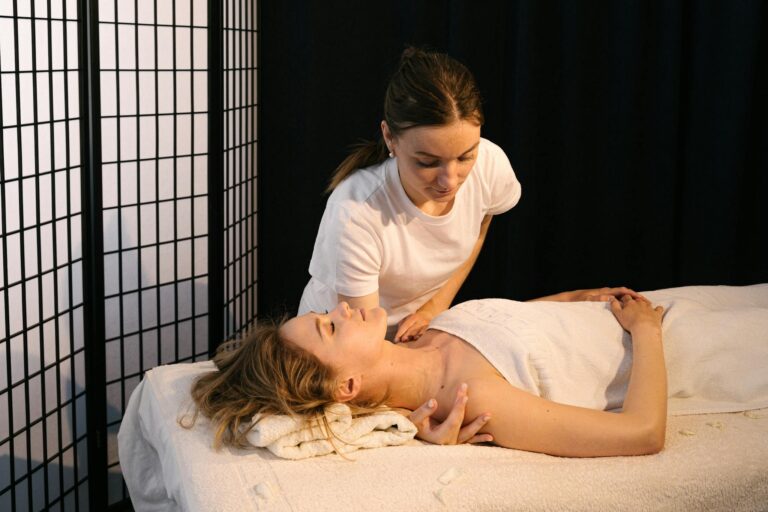 A masseuse provides therapeutic massage to a woman in a tranquil spa setting.